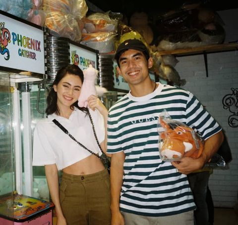 Ter Chantavit in a green-white t-shirt with Davika Hoorne, white top and brown pants.