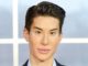 Justin Jedlica wearing a suit looks at the camera.