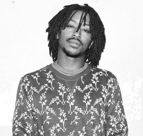 Iman Omari nods right in a black and white background 