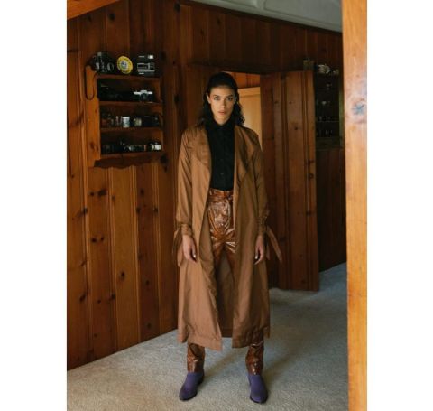 Laysla De Oliviera in a brown coat and pants. 