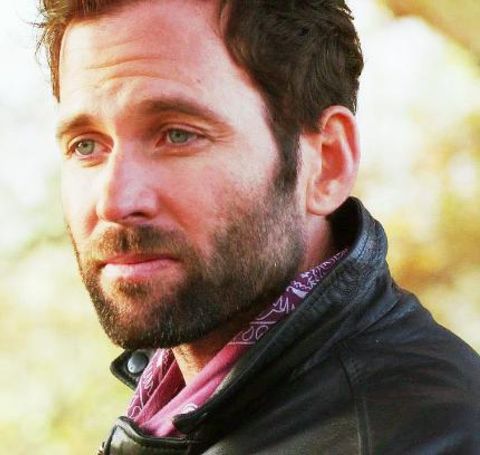 Eion Bailey caught on action as he looks left in his black leather jacket.