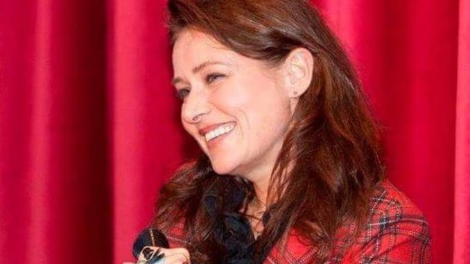 Sidse Babett Knudsen in a red dress at a mic.
