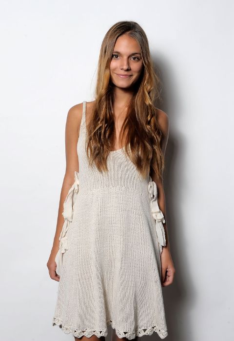 Actress, Caitlin Stasey giving a pose while wearing a white dress