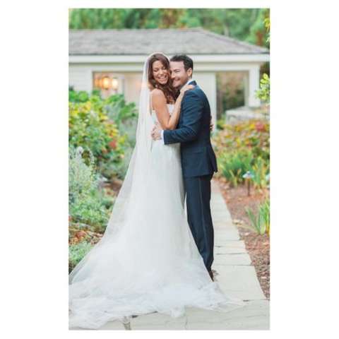 Courtney Henggeler and her husband Ross, holding one another in their wedding dress.