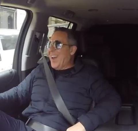 Greg Gutfield in a black t-shirt in his car.