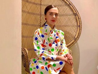 Bel Powley poses during a photoshoot in a colorful dress.