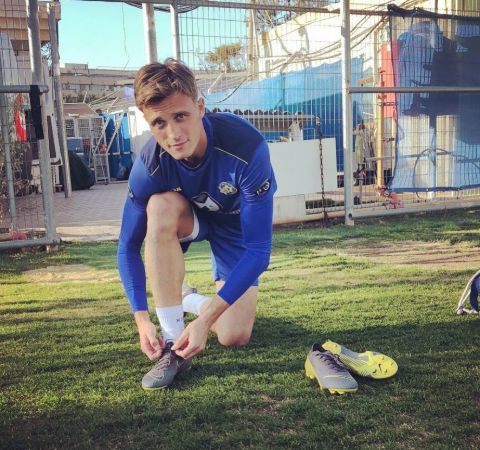 Aaron Schoenfeld getting ready for training ,tying his boots.