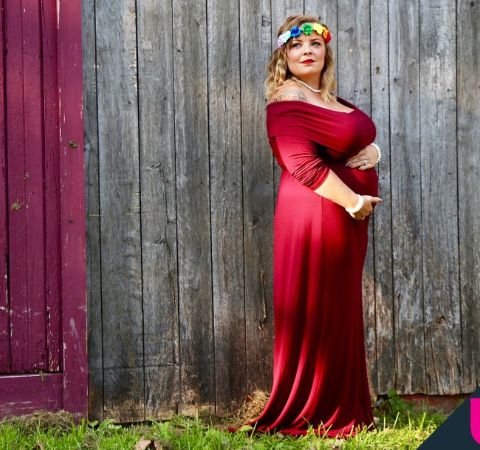 Catelynn Baltierra in a red dress poses while being pregnant. 