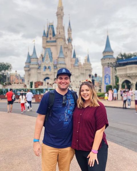 Sierra Schultzzie and her husband giving a pose in front of the famous Disney castle.
