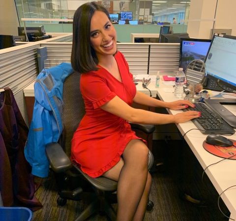 Katie Katro in a red dress in front of her PC.