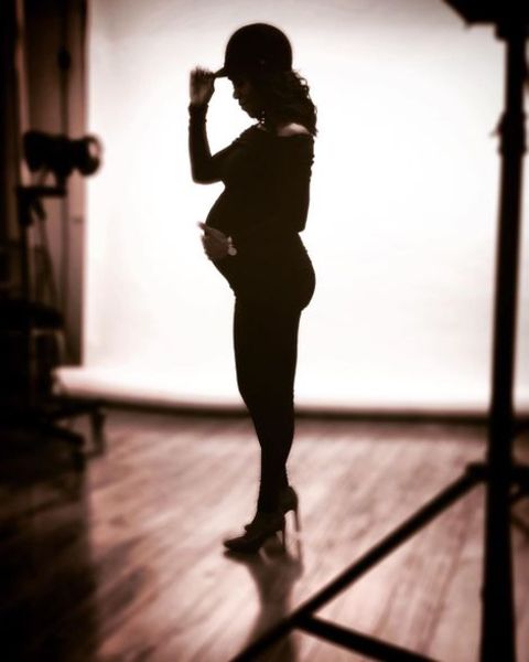 Christie Ileto giving a pose while grabbing her baby bump.