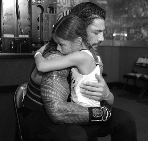 Joelle Anoa'i hugging her father Roman Reigns.