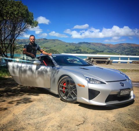 Jordan Mauger poses besides his grey lexus car.