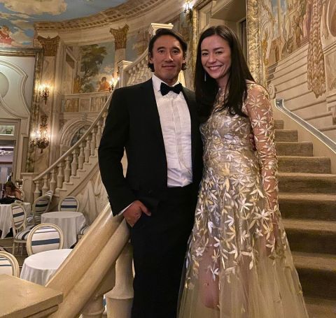 Elizabeth Vasarhelyi in a white gown besides her  husband Jimmy Chin poses for a picture. 