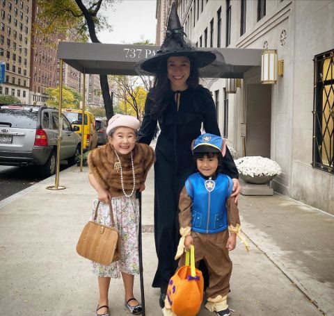 Elizabeth Vasarhelyi in a black outfit poses with her children in Halloween 2019.