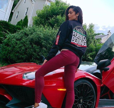 Janira Kremets poses alongside a red Lamborghini.