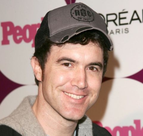 Tom Anderson in a black cap and hood poses a picture.
