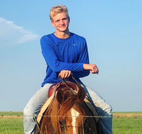 Ree Drummond's son Bryce Drummond in  blue t-shirt riding a horse.