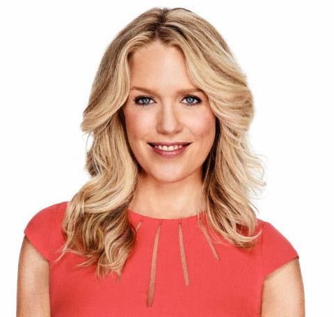 Jessica St.Clair  in a red outfit poses during a photoshoot.