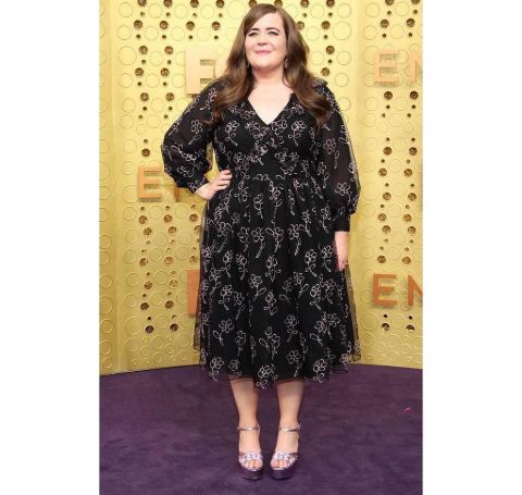 Aidy Bryant in a black dress poses at the Emmy award ceremony.