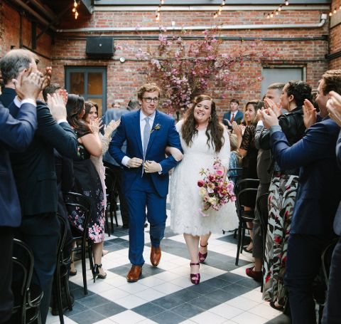 Aidy Bryant and husband Conner O'Malley walk down the aisle in their wedding ceremony.
