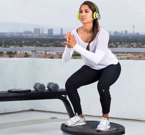 Seema Sadekar in a white t-shirt and black yoga pants working out.