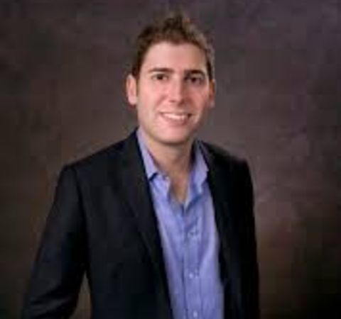 Eduardo Saverin  in a black suit poses for a picture.