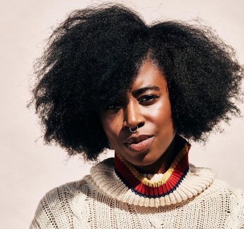 Kirby Howell-Baptiste in a grey hood poses for a picture.
