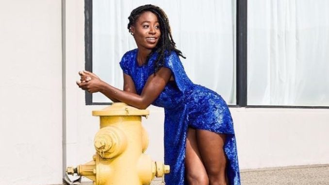 Kirby Howell Baptiste in a blue dress poses for a picture.