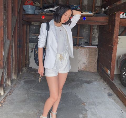 Charlotte Nicdao in a white dress poses for a picture.