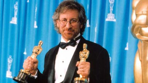 Steven Spielberg giving a pose holding his Oscars.