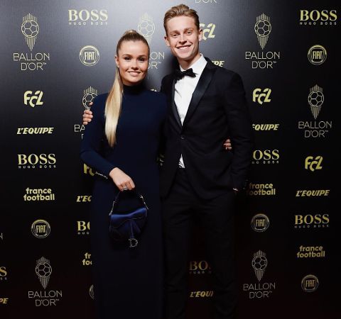 Mikky Kiemeney in a black dress poses with De Jong at an event.