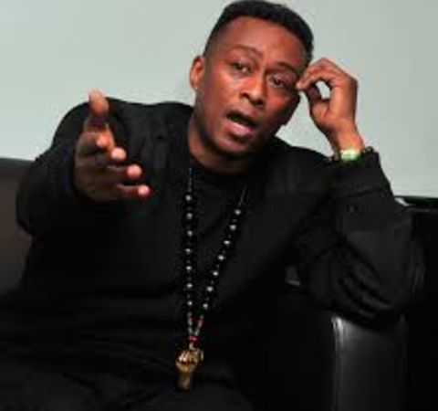 Professor Griff in a black suit poses for a picture.