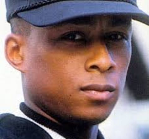 Professor Griff in a black top and hat poses for a picture.