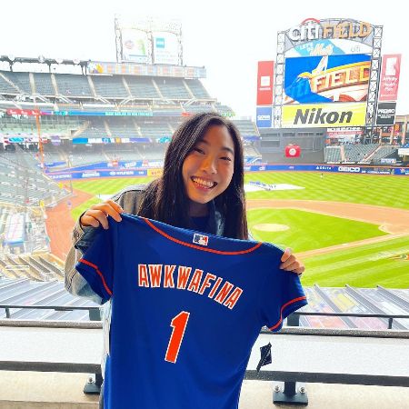 Awkwafina holding her favorite Mets jersey