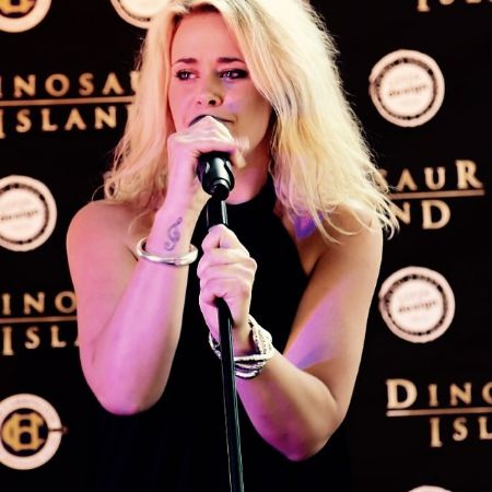  Kate DeAraugo singing at a red carpet event.
