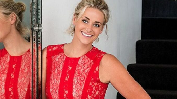 Kate DeAraugo wearing a red dress and posing for a photo.