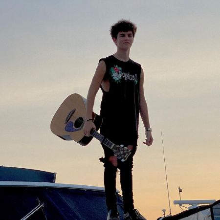  Hayden Summerall holding his guitar and posing for a photo.
