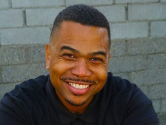 Omar Gooding wearing a black t-shirt and posing for a photo.