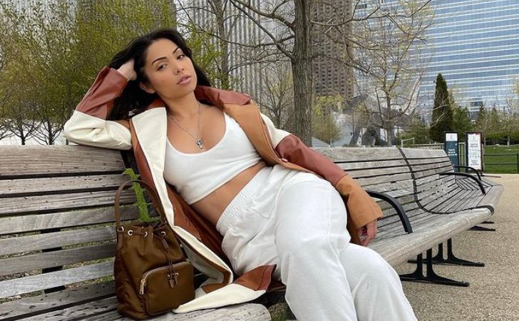Maddy Belle sitting in a bench at a park and wearing white clothes.
